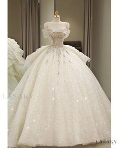 a white ball gown with sequins and beading on the skirt is displayed in front of a mannequin