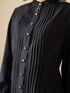 A pleated blouse that looks like an aristocratic lady from medieval Europe. It has a pleated chest and a removable cravat decorated with a cross. The cuffs are long and the waist is tapered. For a young lady with a noble atmosphere. 
 
 

 

 
 
 Color 
 
 Black 
 White 
 Red 
 Light brown 
 
 
 Size 
 
 
 S size 
 
 Length: 63-68cm 
 Shoulder width: 36cm 
 Bust: 86cm 
 Waist: 70cm 
 Sleeve length: 60cm 
 
 M size 
 
 Length: 64-69cm 
 Shoulder width: 37.5cm 
 Bust: 92cm 
 Waist: 76cm 
 Sleeve l Elegant Pleated Blouse For Evening, Elegant Pleated Evening Blouse, Elegant Stand Collar Top With Buttons, Gothic Formal Tops For Fall, Fitted Black Pleated Tops, Elegant Black Pleated Blouse, Elegant Stand Collar Blouse With Buttons, Elegant Fitted Blouse With Covered Buttons, Elegant Pleated Formal Tops