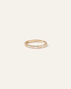 a gold ring with three small diamonds on the side, set against a white background