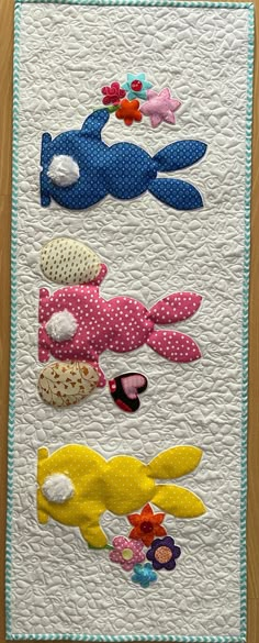 a quilted wall hanging with fish on it