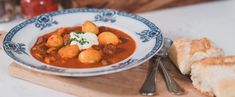 a bowl of stew with bread on the side