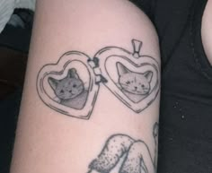 a couple of tattoos on the arm of someone's legs with cats in heart shaped frames