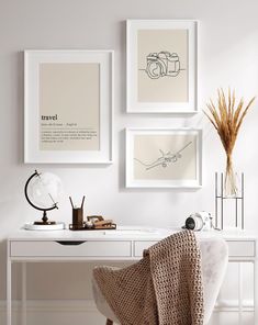 three framed photographs hang on the wall above a white desk with a chair and lamp