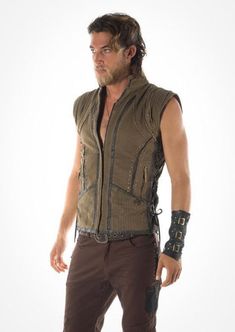 With its distinctive Viking flavor the Odin vest is durable and hard wearing. Made from 100% cotton this double lined vest will keep you warm even on the longest winters night. The inner lining is a soft cotton, the outside is hard wearing canvas weave. It has a zip up front with leather detail panels, brass studs, lace up sides, and an array of open and zipper pockets in the front with an extra breast pocket in the lining, It also boasts an elegant leather hand braiding embellishment down the s Winter Biker Sleeveless Vest, Punk Tank Top For Cosplay, Punk Style Sleeveless Tank Top For Cosplay, Alternative Sleeveless Vest For Alternative Fashion, Steampunk Black Sleeveless Vest, Steampunk Style Sleeveless Black Vest, Black Steampunk Sleeveless Vest, Black Sleeveless Steampunk Vest, Punk Style Sleeveless Vest For Festival