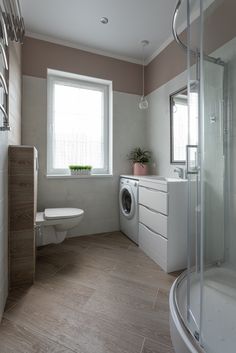 a bathroom with a washer and dryer in the corner next to a window