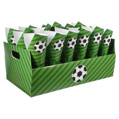 a green box filled with lots of cups and soccer balls on top of each other