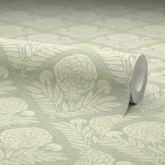 a roll of toilet paper sitting on top of a table next to a wallpaper