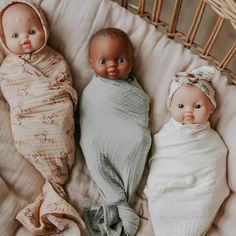 three baby dolls laying next to each other