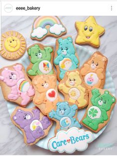 there are many decorated cookies on the plate with teddy bears and rainbows in the background