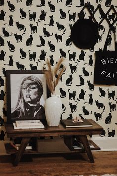 a black and white cat wallpaper with a wooden table in the foreground, an image of a woman's face on it