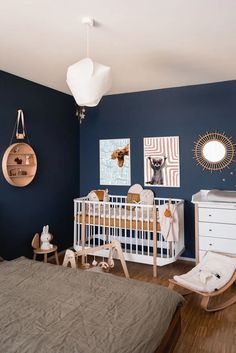 a baby's room with blue walls and white furniture