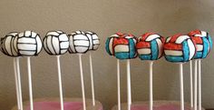 three cake pops decorated with volleyball balls on sticks