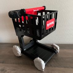 a black shopping cart sitting on top of a wooden table