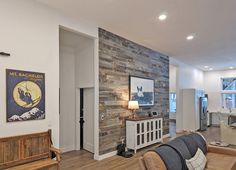 Gray reclaimed wood accent wall in an open floor plan room. Loves Shiplap Wood Planks, Old Trailer Remodel, Trailer Remodel Single Wide, Wood Planks For Walls, Reclaimed Wood Wall Panels, Plank Row, Moving To Tennessee, Wall Accents Decor, Single Wide