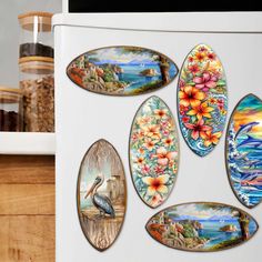 a refrigerator with magnets on the front and side of it decorated with tropical scenes