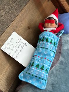 an elf is sitting on top of a bed next to a note