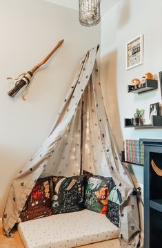 a bed with a canopy and pillows on it in a room next to a book shelf