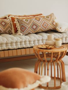 a living room with a couch, table and pillows on the floor in front of it