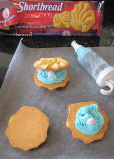 some cookies are sitting on a cookie sheet with frosting and icing next to them