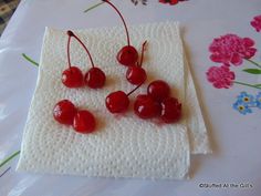 four cherries are sitting on top of a napkin