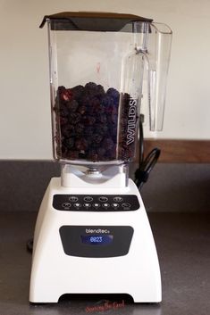 a blender filled with berries sitting on top of a counter