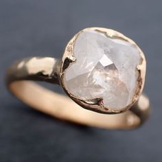 a gold ring with a large white diamond