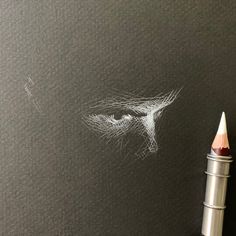 a pencil is next to a drawing of a woman's face on a blackboard