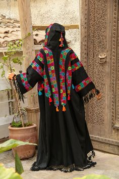 Traditional Kaftan With Tassels, Traditional Multicolor Kaftan With Tassels, Embroidered Black Kaftan For Traditional Ceremonies, Traditional Kimono With Tassels, Traditional Long Sleeve Kaftan With Tassels, Black Long Outerwear For Festivals, Festive Black Kaftan With Traditional Patterns, Long Black Outerwear For Festival, Traditional Black Abaya With Floral Embroidery