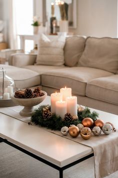 A coffee table with simple Christmas decor, featuring candles, pinecones, and minimal greenery for an understated holiday touch. Table Decor Inspiration