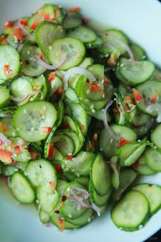 a white bowl filled with cucumbers and onions