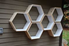 four hexagonal shelves mounted to the side of a house