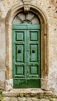 an old green door is shown in front of a stone building