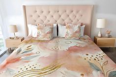 a bed with pink flowers and gold dots on it