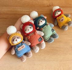 several small stuffed animals are placed in the palm of a person's hand on a wooden surface