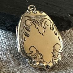 "A Vintage fancy shield shaped Lockewt Gold-filled, paste jewels, lovely hand end engraved design.  Condition is good for its Age any slight wear or age to stones commensurate with age-photos show the details.  size 1 1/8\" by 7/8\", closes tight, hinge is good, inside clean.  If you love vintage lockets this is Treasure from the past." Pyrope Garnet, Vintage Locket, Age Photos, Engraved Flower, Vintage Lockets, Engraved Design, Long Drop Earrings, Love Vintage, Diamond Charm