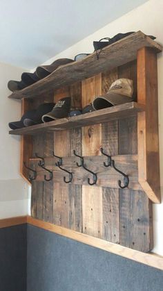 a wooden shelf with shoes on it and hooks hanging from the wall next to each other