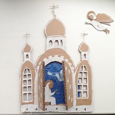 a paper cut out of a church with an image of a dove flying over it