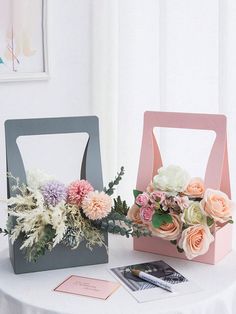 two boxes with flowers are sitting on a table