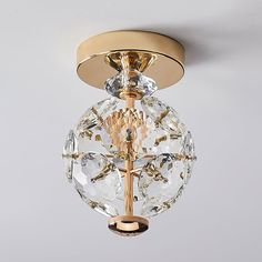 a golden ceiling light with clear crystal balls hanging from it's center point,