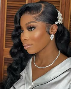 a woman with long hair wearing a white dress and pearls in her hair, looking off to the side