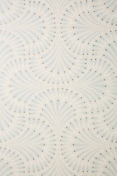 a blue and white wallpaper with small dots on the top, in an ornate pattern