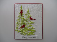 a handmade christmas card with red birds and green pine trees on white cardstock