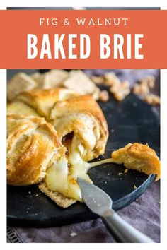 an image of baked brie on a black plate with a knife and fork next to it