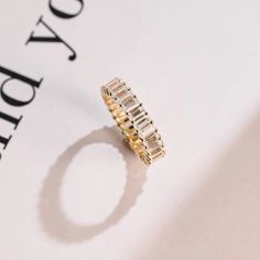 a diamond ring sitting on top of a piece of paper with the word joy written below it