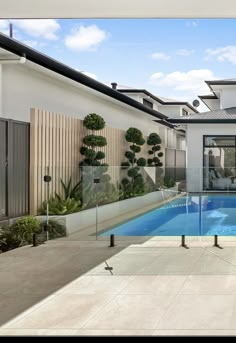 an empty swimming pool in the middle of a home's patio area with glass railings