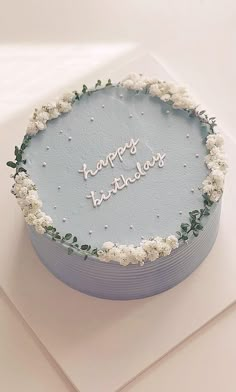 a blue birthday cake with the words happy birthday written in frosting and sprinkles