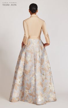 the back of a woman wearing a long dress with floral print on it and a high neck