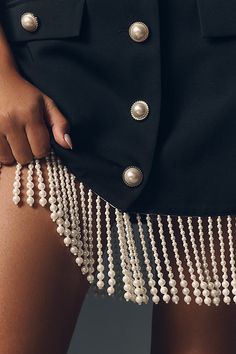 a close up of a woman's skirt with pearls on it