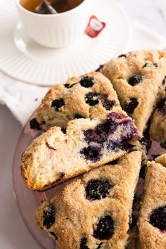 blueberry scones on a plate next to a cup of tea