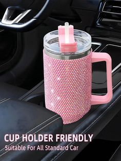 a pink cup holder is in the center of a car